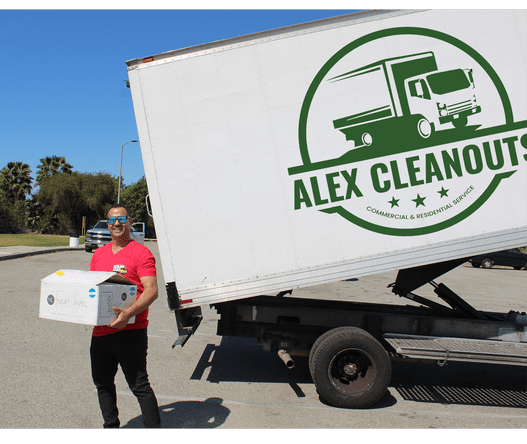 founder Alex standing next to junk truck while holding a box