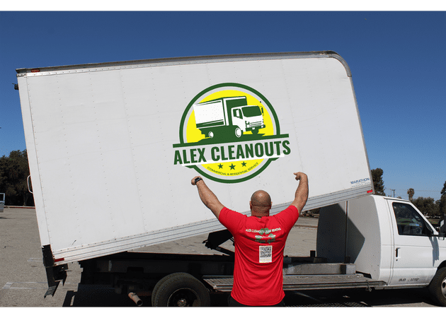 Guy pointing Alex Cleanouts logo stickered on a white truck